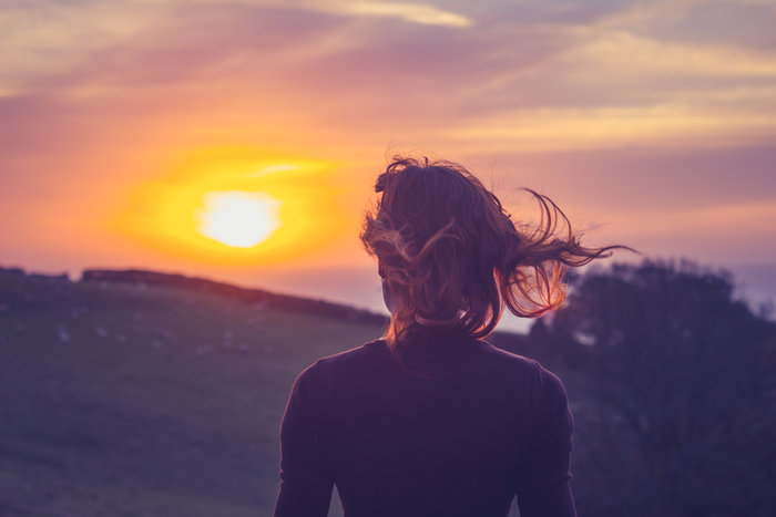 woman looking out over sunset