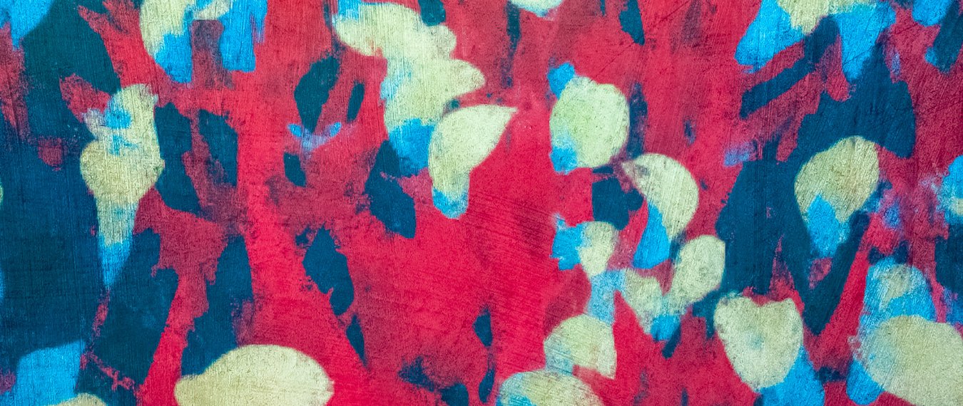 A pattern of pale green flowers on a red and blue background