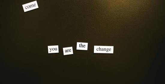 White single-word tiles on a dark background spelling out 'you are the change'.