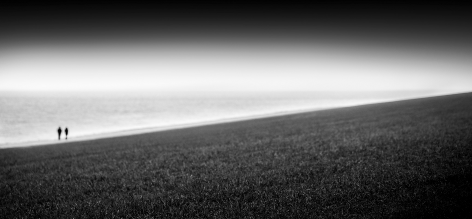 two people walking on a beach