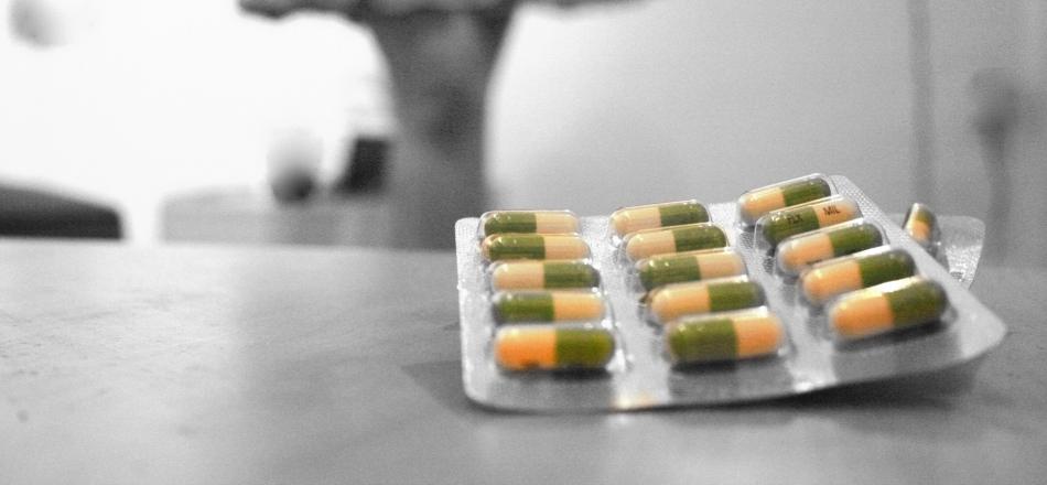 packet of prozac pills sitting on a counter with a figure in the background