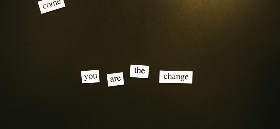 White single-word tiles on a dark background spelling out 'you are the change'.