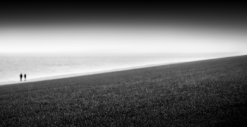 two people walking on a beach